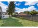 A view of a well maintained lawn, fenced in yard, neighboring houses, and some trees at 2164 Rj Cir, Kissimmee, FL 34744