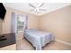This bedroom features a window with blinds and curtains, a ceiling fan, and a cozy bed at 2164 Rj Cir, Kissimmee, FL 34744