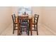 Cozy dining area features a round table with four chairs and natural light from the window at 2164 Rj Cir, Kissimmee, FL 34744