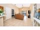 Open living room features neutral tile flooring, vaulted ceiling, and sliding doors to the patio at 2164 Rj Cir, Kissimmee, FL 34744