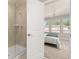 Glass enclosed shower with a door open showing view of a bedroom at 2203 Gopher Tortoise Ter, Oakland, FL 34787