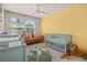 Bright Bedroom with a yellow accent wall, crib, sofa, and play area for a cheerful space at 2203 Gopher Tortoise Ter, Oakland, FL 34787