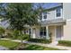 Inviting townhouse featuring a cozy front patio with outdoor seating and landscaped yard at 2203 Gopher Tortoise Ter, Oakland, FL 34787