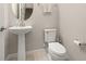 Bright half-bathroom featuring a pedestal sink, toilet, and tiled floor with chrome fixtures at 2203 Gopher Tortoise Ter, Oakland, FL 34787