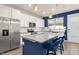Bright kitchen with white cabinets, granite countertops, stainless steel appliances, and a blue island at 2203 Gopher Tortoise Ter, Oakland, FL 34787