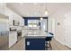 Modern kitchen featuring white cabinets, stainless steel appliances, and a blue kitchen island with seating at 2203 Gopher Tortoise Ter, Oakland, FL 34787