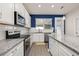 Stylish kitchen with white cabinets, granite counters, stainless appliances and modern pendant lighting at 2203 Gopher Tortoise Ter, Oakland, FL 34787