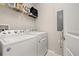 Well-lit laundry room featuring a white Whirlpool washer and dryer with a gray utility panel at 2203 Gopher Tortoise Ter, Oakland, FL 34787