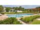 Community pool with brick surround, lounge chairs, pergola, and lush landscaping at 2203 Gopher Tortoise Ter, Oakland, FL 34787