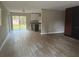 Open floor plan showing the living room leading into the kitchen, with wood-look floors throughout at 225 W 2Nd St, Chuluota, FL 32766