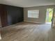 Modern living room with wood-look tile flooring, natural light, and decorative wall accents at 225 W 2Nd St, Chuluota, FL 32766