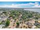 A high aerial view showing houses and surrounding streets, businesses, and a lake in the distance at 2631 Mcdonald Ter, Mount Dora, FL 32757