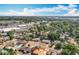 A high aerial view of homes with mature trees, and commercial development under a partly cloudy sky at 2631 Mcdonald Ter, Mount Dora, FL 32757
