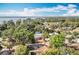 Aerial view of a community with lush trees, homes, and a large lake in the distance under a partly cloudy sky at 2631 Mcdonald Ter, Mount Dora, FL 32757