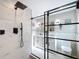 Modern bathroom featuring white double vanity, tiled walls, and a sleek, glass-enclosed shower at 2631 Mcdonald Ter, Mount Dora, FL 32757