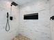 Stylish shower with white tile walls, pebble floor, and matte black fixtures and inset at 2631 Mcdonald Ter, Mount Dora, FL 32757