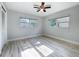 Spacious bedroom with two windows, light walls and light wood floors, and ceiling fan at 2631 Mcdonald Ter, Mount Dora, FL 32757