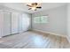 Bedroom features hardwood floors, a ceiling fan, and a large window at 2631 Mcdonald Ter, Mount Dora, FL 32757
