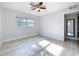 Empty bedroom with ceiling fan, one window, light walls and light wood floors at 2631 Mcdonald Ter, Mount Dora, FL 32757