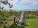 Wooden dock leading to the water, set amongst lush greenery, with a property owner's sign posted at the entrance at 2631 Mcdonald Ter, Mount Dora, FL 32757