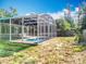 Enclosed pool area features a spacious patio and a clear blue pool surrounded by green trees, offering privacy at 2631 Mcdonald Ter, Mount Dora, FL 32757