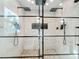 Modern dual shower featuring glass doors, pebble flooring, and stylish fixtures at 2631 Mcdonald Ter, Mount Dora, FL 32757