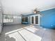 Large sunroom with tiled floor, ceiling fans, and a calming blue accent wall with outdoor access at 2631 Mcdonald Ter, Mount Dora, FL 32757