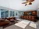 Spacious sunroom featuring a bar with stools and a comfortable lounge area to enjoy the view at 2631 Mcdonald Ter, Mount Dora, FL 32757