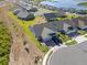 Aerial view showcases a neighborhood with water views, manicured lawns, and well-maintained landscaping at 2681 Spider Lily Ct, Clermont, FL 34711