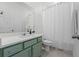The full bath features light green vanity with modern fixtures, a shower-tub, and white accents at 2681 Spider Lily Ct, Clermont, FL 34711