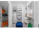 Walk-in closet with custom shelving, organization, and a comfortable blue ottoman at 2681 Spider Lily Ct, Clermont, FL 34711