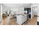 Open-concept kitchen with island, stainless appliances, and wood-style flooring at 2681 Spider Lily Ct, Clermont, FL 34711