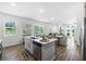 Modern kitchen with stainless steel appliances, island seating, and view into the living area at 2681 Spider Lily Ct, Clermont, FL 34711