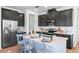 Modern kitchen features dark cabinets, stainless steel appliances, white countertops, and an island with barstool seating at 2681 Spider Lily Ct, Clermont, FL 34711