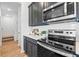 Close-up of kitchen featuring stainless steel appliances, dark cabinets, white countertops, and tile backsplash at 2681 Spider Lily Ct, Clermont, FL 34711