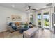 Bright living room featuring a comfortable sofa, accent chairs, and a backyard view at 2681 Spider Lily Ct, Clermont, FL 34711