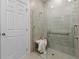 Walk-in shower features neutral tile and a glass enclosure with a seating bench at 2681 Spider Lily Ct, Clermont, FL 34711