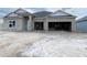 Unfinished exterior of a single-story home with a two-car garage and concrete block construction at 2703 Ravencliffe Ter, Oviedo, FL 32765