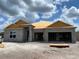 Exterior view of home under construction, showcasing the block structure and roof framework under a cloudy sky at 2703 Ravencliffe Ter, Oviedo, FL 32765