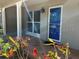 Inviting tiled front porch with vibrant flowers, complemented by a blue-trimmed door and adjacent window at 2886 Carew Ave, Winter Park, FL 32789