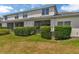 Rear exterior view of home with screened-in lanai and manicured lawn and hedges at 2956 Oak Park Way # B, Orlando, FL 32822