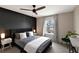 Modern bedroom with a dark accent wall, ceiling fan, and cozy bedding at 2956 Oak Park Way # B, Orlando, FL 32822