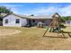 Spacious backyard featuring mature trees, play equipment, and ample space for outdoor enjoyment at 3041 Dikewood Ct, Winter Park, FL 32792