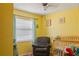 Cozy Bedroom featuring a comfortable chair, crib, and window for natural light at 3041 Dikewood Ct, Winter Park, FL 32792