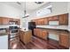 Functional kitchen with wood cabinets, stainless steel appliances, an island, and hardwood floors at 308 Pine Shadow Ln, Lake Mary, FL 32746