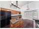 Well-equipped kitchen featuring an island, wood cabinets, granite counters, and hardwood floors at 308 Pine Shadow Ln, Lake Mary, FL 32746