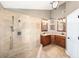 Main bathroom featuring double vanities, decorative mirrors, and an all tile walk-in shower at 308 Pine Shadow Ln, Lake Mary, FL 32746