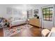 Cozy bedroom with a colorful rug, daybed, dresser, and bright natural light from the two windows at 3420 Dawn Ct, Lake Mary, FL 32746