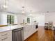 Kitchen island features stainless dishwasher and microwave, farm sink, and seating under modern lighting at 3420 Dawn Ct, Lake Mary, FL 32746
