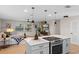 Modern kitchen boasts a large center island with pendant lighting, stainless steel appliances, and open living area at 356 Oakhurst St, Altamonte Springs, FL 32701